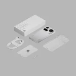 White smartphone with triple rear cameras, plus its box, charging cable, transparent case, SIM tray tool, and quick-start card on a gray background.
